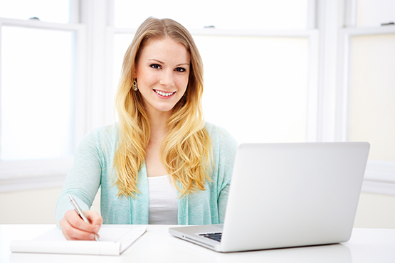 Smiling Young Woman at a desk with a computer